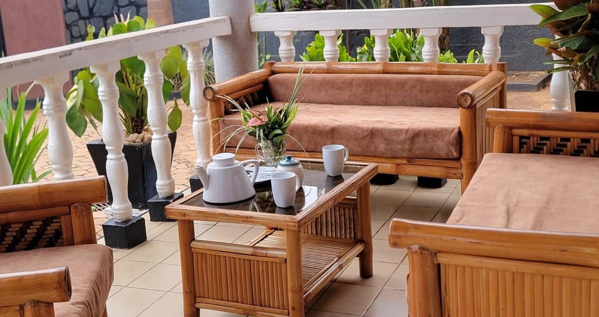 Un coin salon extérieur en bambou avec une table, des tasses et une théière.